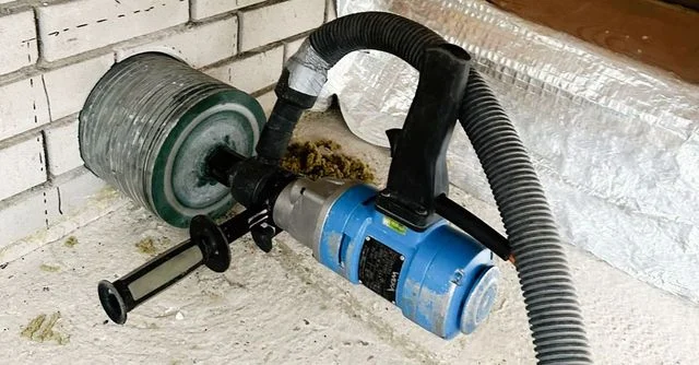 Droog boren van een wanddoorvoer met aangesloten stofafzuiging