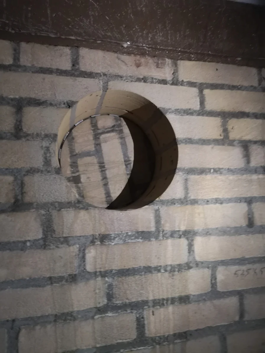 Grote ronde opening door gemetselde bakstenen wand