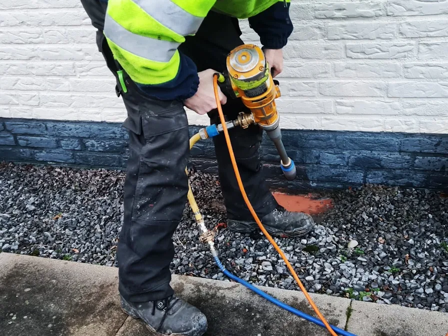 Drillpro boort een nieuw ventilatiepunt onderaan de gevel